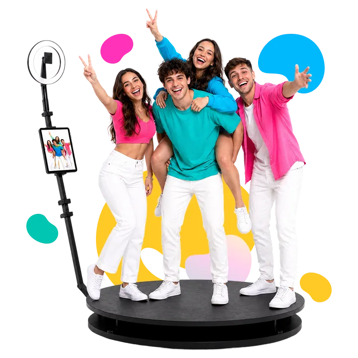 360-Degree Photo Booth Four young adults posing on a circular platform with a 360 photo booth, making peace signs and celebratory gestures while colorful speech bubbles surround them