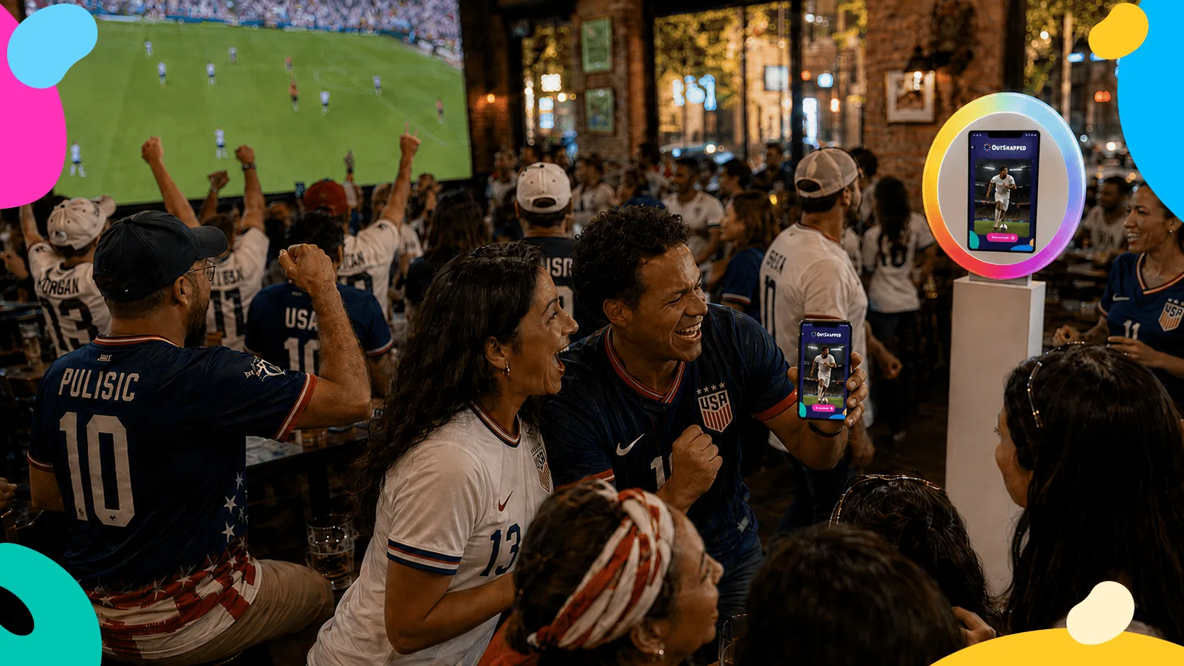 AI Photo Booth at Live Sports Watch Party Crowds at a Big Game watch party wearing USA sports jerseys, with an AI photo booth displaying on a screen in the right foreground, colorful geometric shapes framing the scene.