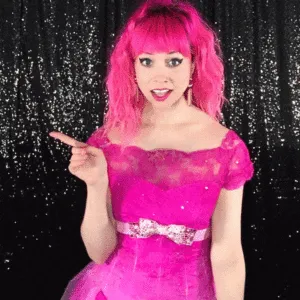 Dynamic Poses for Energetic Boomerangs Woman with pink wig smiling broadly while pointing with animated gesture
