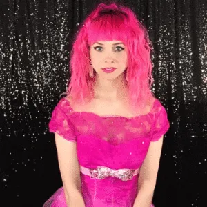 Boomerang Photo Booth Styling Tips Woman in vibrant pink wig and hot pink off-shoulder dress with sparkly waistband
