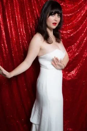 Bride in white strapless dress against red sequined backdrop
