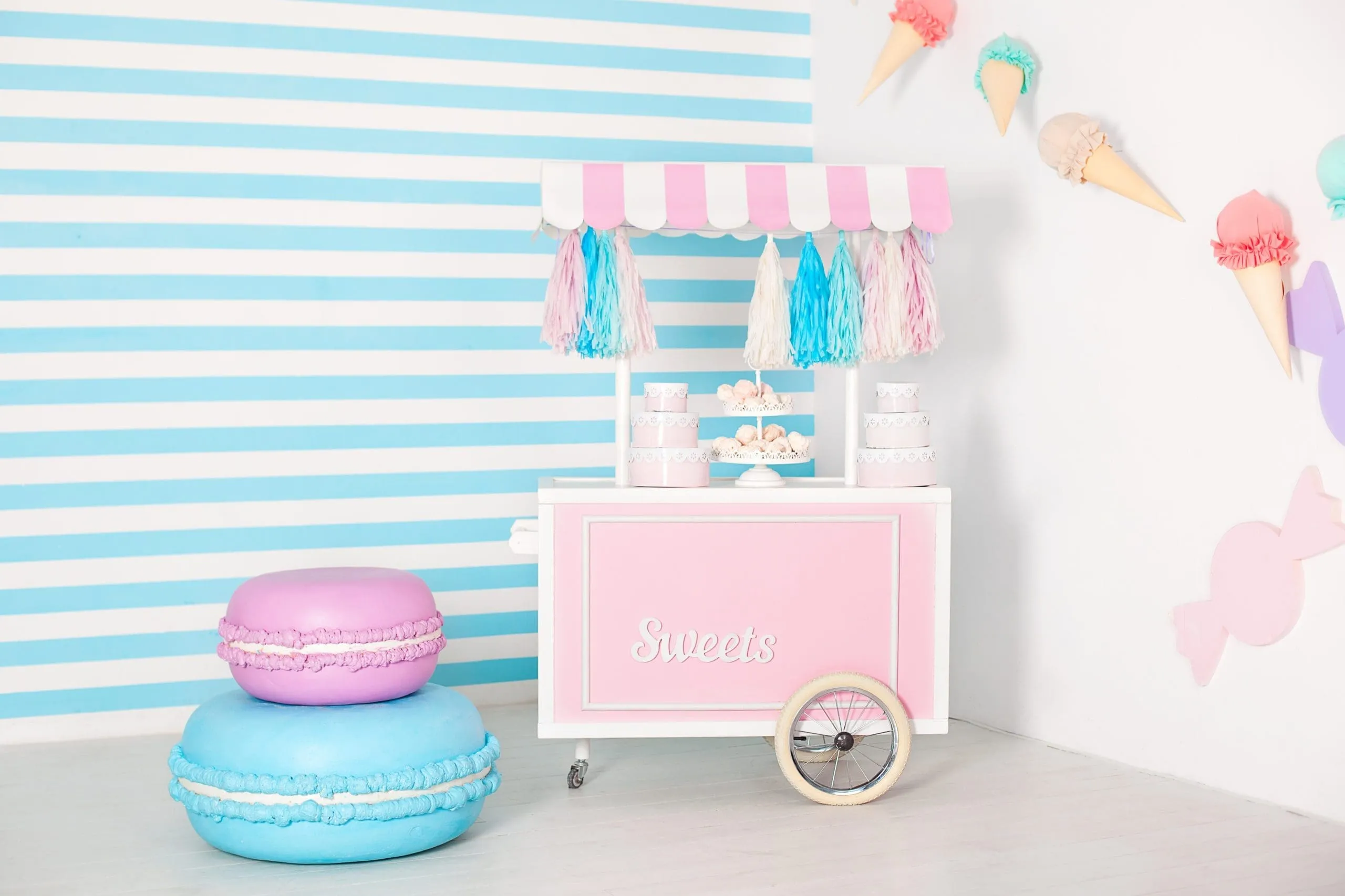 Pastel Candy Shop Photo Booth Setup Candy shop photo booth with striped backdrop, oversized macarons, and ice cream props