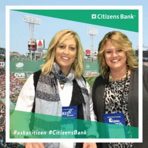 Two women smile at Citizens Bank trade show photo booth with baseball stadium in background, green Citizens Bank branding frame