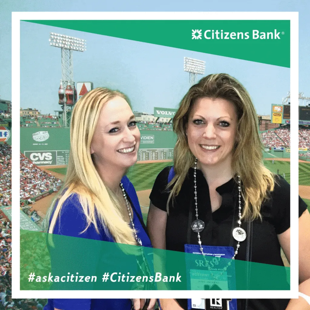 Two women smiling at Citizens Bank-branded photo booth with Fenway Park stadium backdrop, NAR convention