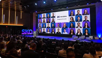 Corporate Conference Headshot Display Wall Large conference stage display showing grid of employee headshots with audience seated below