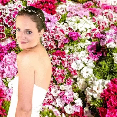Romantic Floral Wall Green Screen Bride with flower crown against vibrant pink, white, and fuchsia floral bloom backdrop
