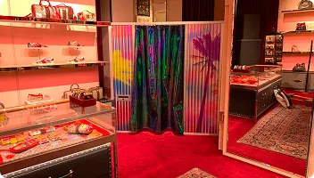 Photo Booth Installation in Luxury Retail FutureFoto open-air photo booth with colorful corrugated metal panels installed in luxury retail showroom with red carpet and illuminated display shelving