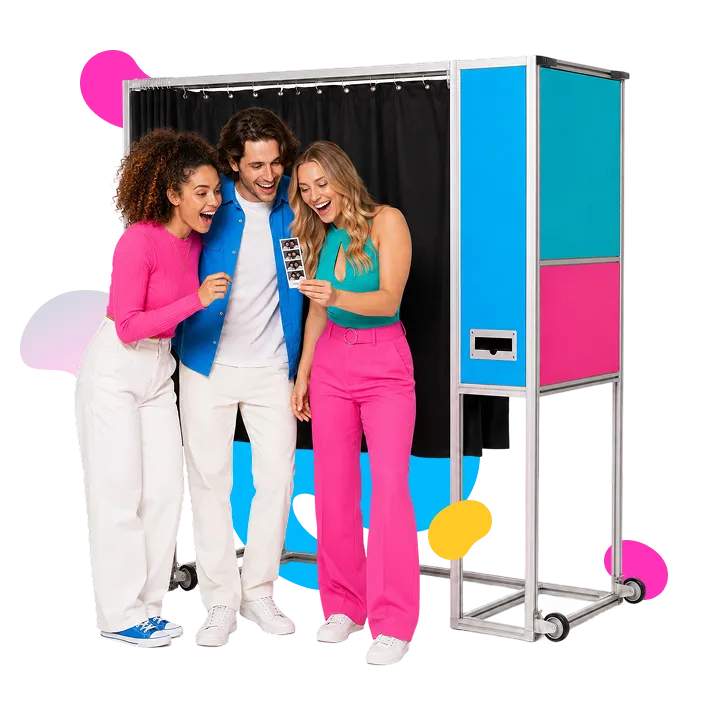 MagBooth Photo Booth Experience Three smiling guests posing inside and around a FutureFoto open-air photo booth with black curtain backdrop, bright blue and hot pink panels, and metallic frame on wheels.