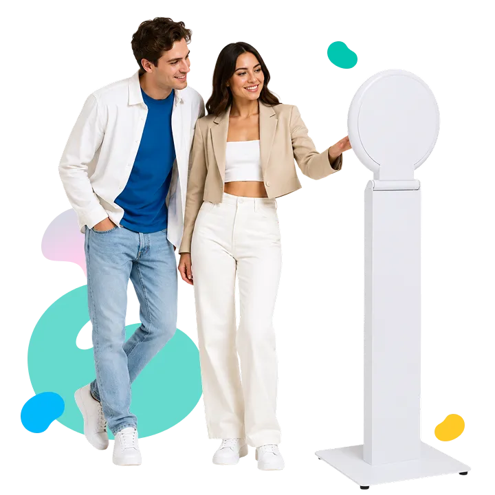Couple posing next to white pedestal FutureFoto AI video booth with colorful decorative elements