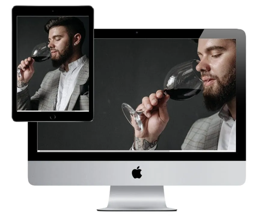 Man in professional attire tasting wine displayed on iMac and tablet screens for hybrid event participation