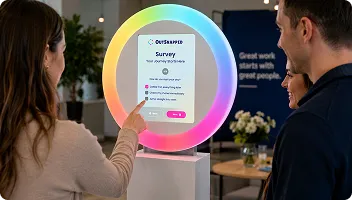 Two attendees interacting with circular interactive feedback display screen at event