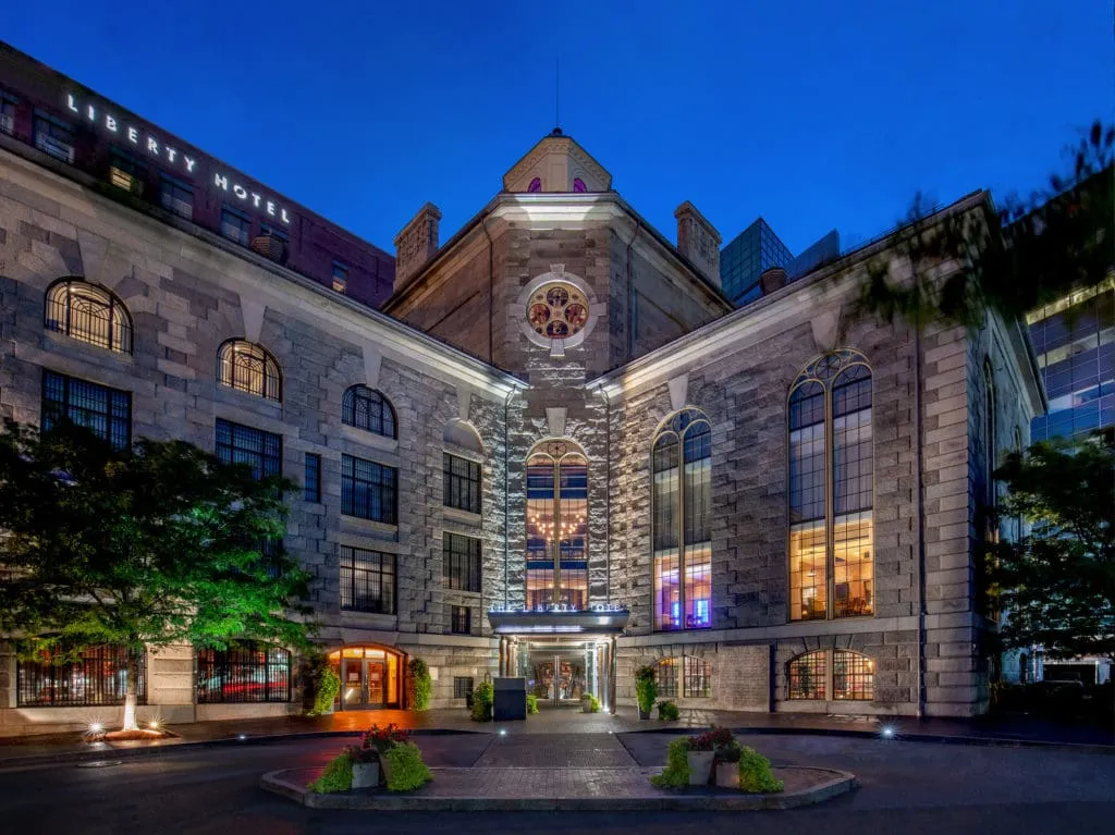 Liberty Hotel Boston exterior at dusk, illuminated historic building with clock tower and arched windows, venue for corporate events