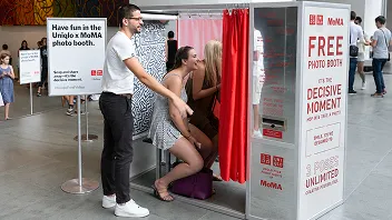 MagBooth retro photo booth at UNIQLO MOMA activation with man and woman posing inside red curtained enclosure