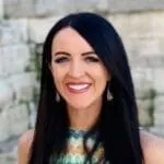 Natalie Carter - OutSnapped Photo Booth Client Woman with long black hair wearing sleeveless top smiling at camera outdoors