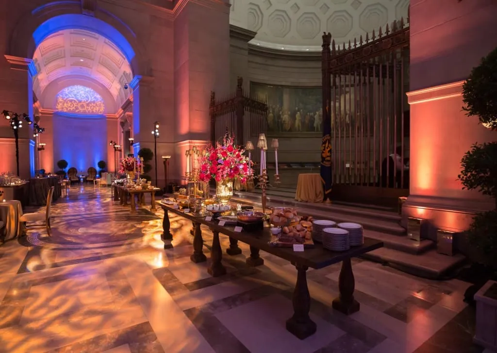 National Archives Rotunda Formal Reception Venue Elegant reception setup with formal tables in arched gallery with dramatic blue and orange lighting