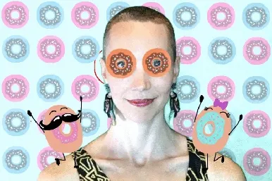 Doughnut Day photo booth filter with donut eye effects Person wearing oversized donut-shaped novelty glasses with animated donut characters on shoulders against pastel pink and blue donut pattern background.