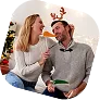 Holiday Party Photo Booth Experience Two people smiling while posing in an open-air photo booth, wearing festive attire for a holiday celebration
