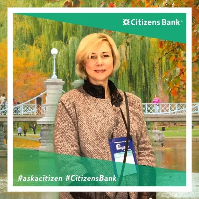 Woman in business attire with name badge at photo booth with garden virtual background