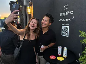 QR-Powered Selfie Spot — Mobile Photo Capture Event attendees using QR code at selfie spot activation with branded backdrop