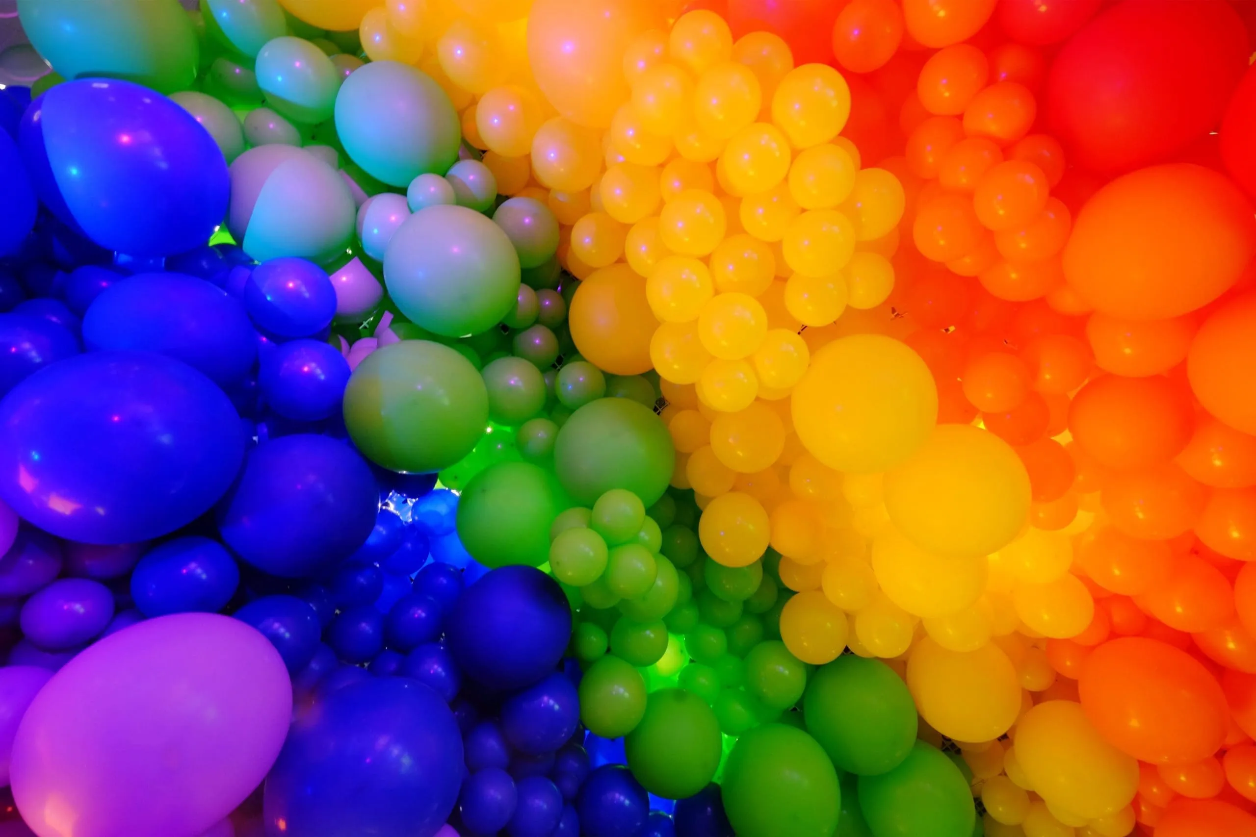 Rainbow Gradient Balloon Photo Booth Backdrop Gradient balloon wall backdrop with rainbow colors from blue to red, varying balloon sizes