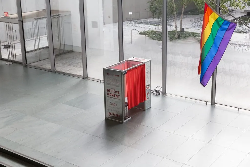 In-Store Photo Booth Installation in Retail Venue Red open-air photo booth with pride flag in modern retail storefront with large windows
