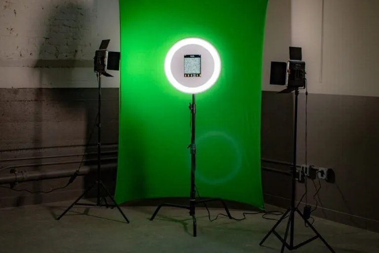 iPad ring light photo booth with green screen setup AI photo booth setup with iPad mounted in white ring light, green screen backdrop, and professional lighting stands for wedding events