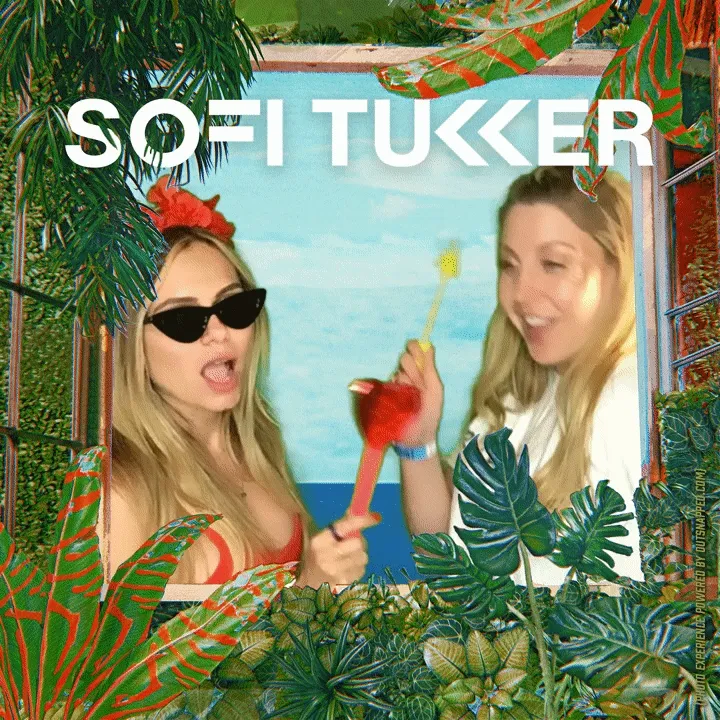 Interactive Prop Experience at Photo Booth Event Two women posing with tropical flower props at photo booth