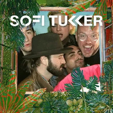 Group Photo Experience in Themed Photo Booth Sofi Tukker band members posing together in OutSnapped photo booth with tropical leaf frame and colorful decorations