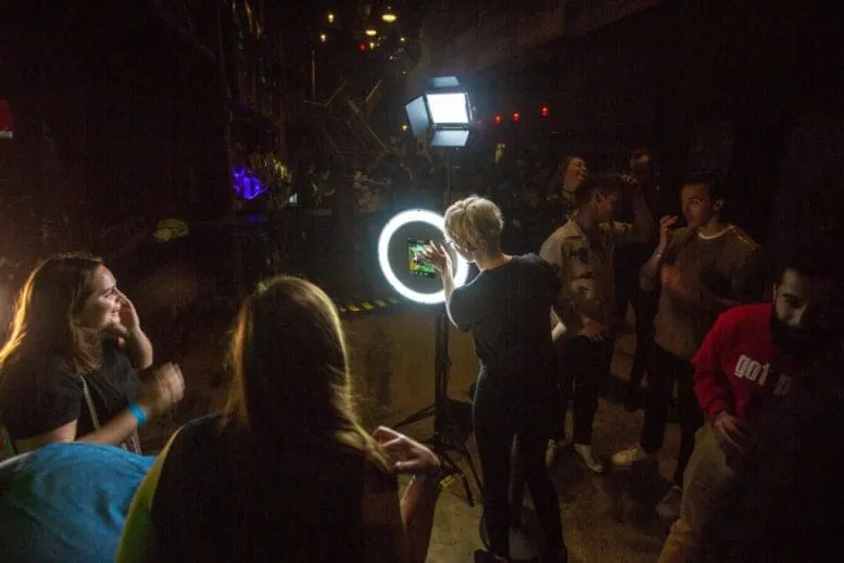 SoFi Tukker treehouse tour photo booth Guests posing with a glowing circular light ring photo booth at Sofi Tukker's Treehouse Tour concert event