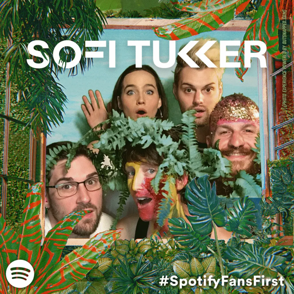 Creative Prop Usage in Photo Booth Experience Sofi Tukker band members posing playfully in OutSnapped photo booth with tropical foliage props during Treehouse Tour