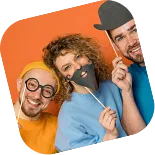 Event Guests Enjoying Photo Booth Props Three smiling people wearing colorful props and glasses at a photo booth celebration