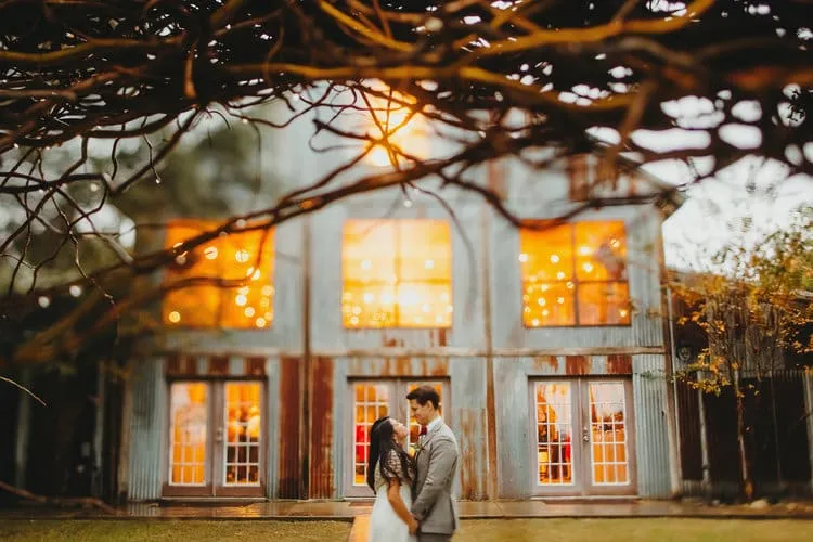 Vista West Ranch: Rustic Elegance for Austin Wedding Celebrations Bride and groom at illuminated Vista West Ranch barn venue