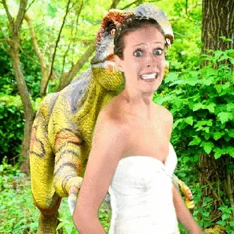 Bride with T-Rex green screen effect Bride in white strapless dress with elaborate updo and flower crown, posing with large green reptile on shoulder against forest backdrop