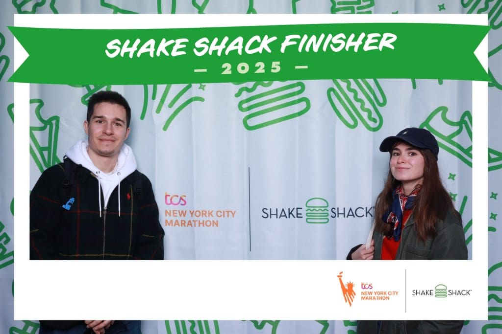 NYC Marathon Photo Booth Rental Case Study: How Shake Shack Generated 50K+ Impressions at the Finish Line 3 NYC Marathon finishers posing together in OutSnapped's Shake Shack branded photo booth frame at 2025 TCS Marathon finish line, deliberately framing Shake Shack and TCS New York City Marathon logos in their celebratory shot